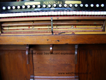 Mannborg harmonium met inrichting voor gescheiden bas/discant expressie; hendel staat in middenstand: expression zowel bas als discant.
                Indien hendel naar links: expression bas en discant via magazijnbalg; indien hendel naar rechts; expression discant en bas via magazijnbalg.